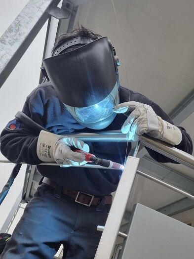 Edelstahlschweißer schweißt Geländer